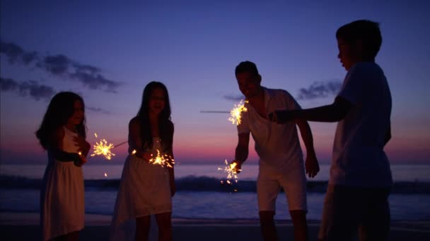 family on beach with sparklers<br>